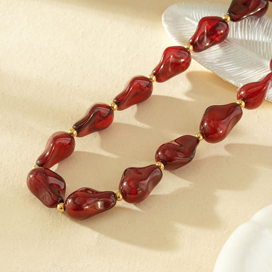 Collier résine formes irrégulières bordeau séarateurs dorés