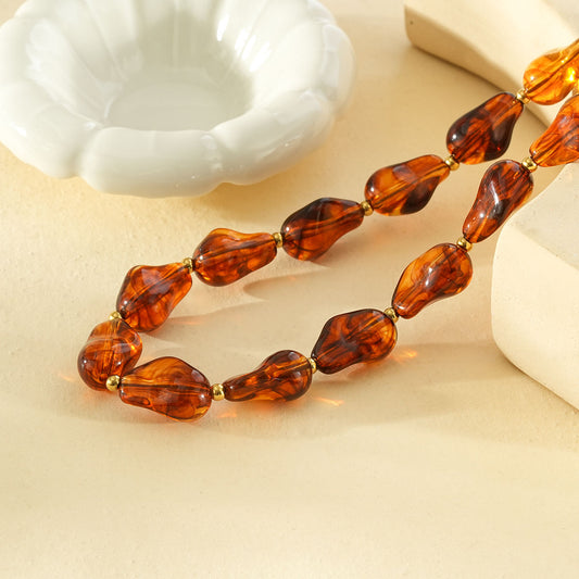 Collier résine formes irrégulières marron ambré séarateurs dorés