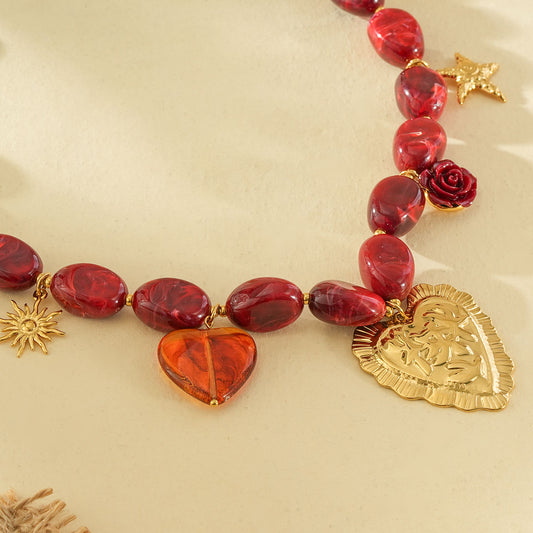 Collier résine rouge et pendentifs dorés cœurs ex-voto