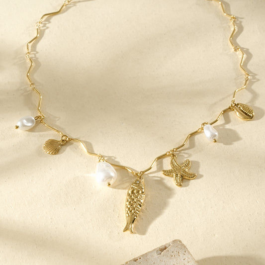 Collier doré chaîne ondulée perles et breloques marines