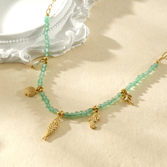 Collier doré perles vert d’eau et pendentifs marins