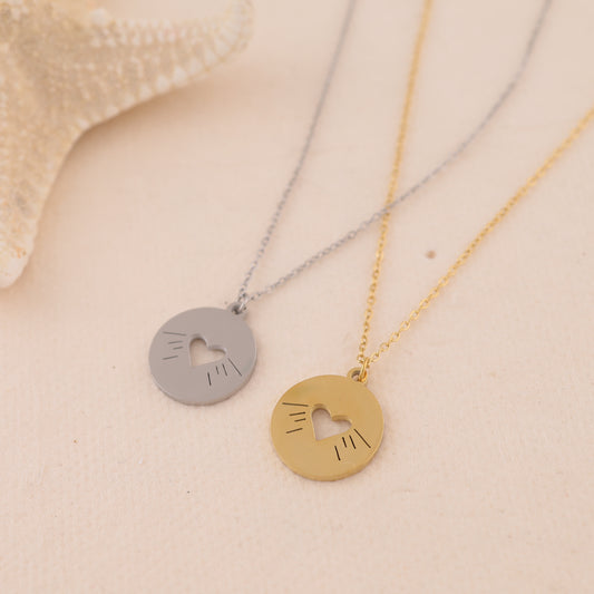 Collier doré chaîne fine avec pendentif rond ajouré cœur central et gravures