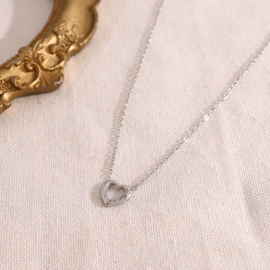 Collier argenté fin avec pendentif cœur ajouré serti de trois strass