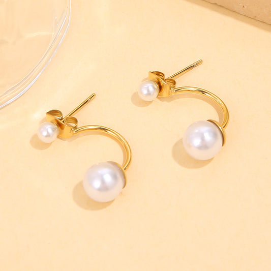 Boucles d’oreilles dorées courbées avec mini perle et perle centrale