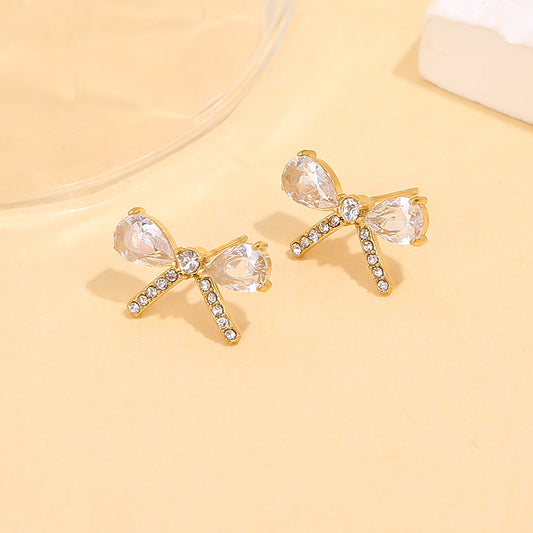 Boucles d’oreilles dorées en forme de nœud serties de strass