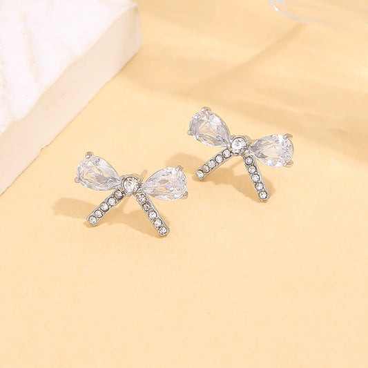 Boucles d’oreilles argentées en forme de nœud serties de strass