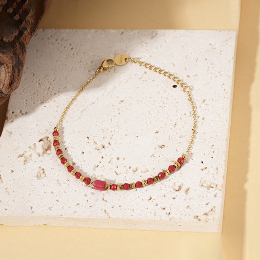 Bracelet doré chaîne fine pierres rouges pierre centrale cylindrique