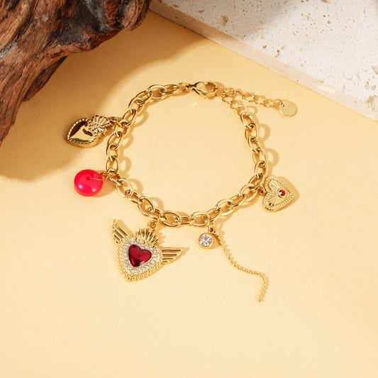 Bracelet doré pendentifs cœurs ex-voto ailes strass rouge
