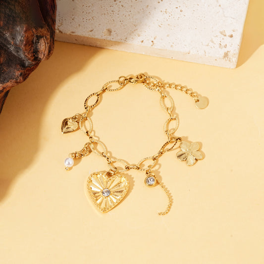 Bracelet doré à maillons ovales avec charms cœur strassé, fleur et perle