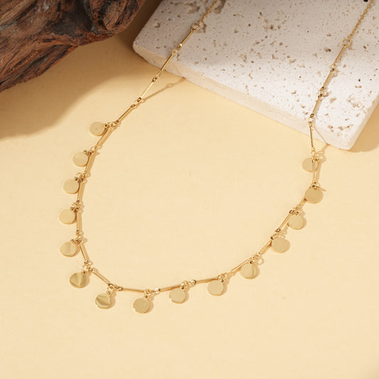 Collier doré chaîne fine orné de pastilles rondes brillantes barres lisses