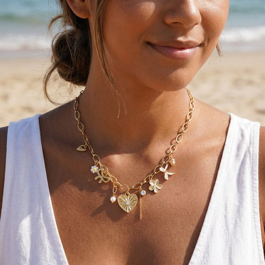 Collier doré à maillons ovales avec charms cœur strassé, fleur et nœud perlé