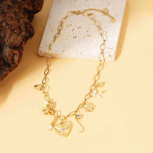Collier doré à maillons ovales avec charms cœur strassé, fleur et nœud perlé