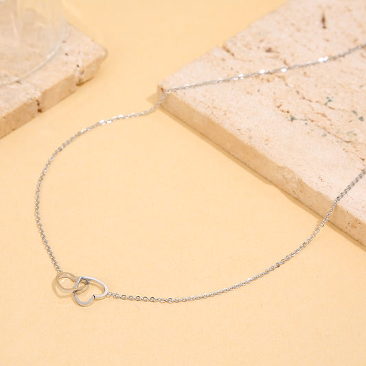 Collier argenté à maillons fins reliés par des cœurs entrelacés