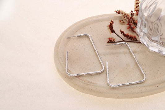 Boucle d'oreilles créoles demi-ouvertes argenté trapèze allongé finition martéolée texturée