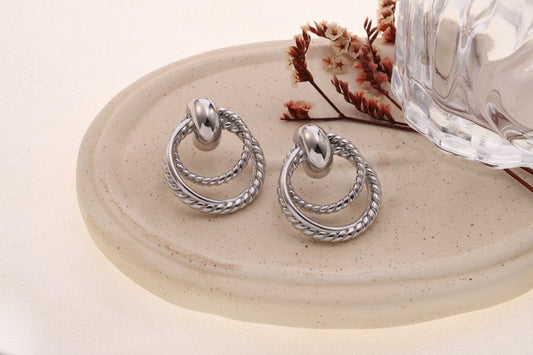 Boucles d’oreilles argentées double anneaux torsadés reliés par maillon bombé effet poli
