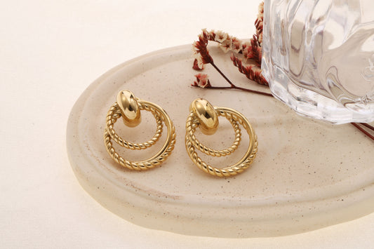 Boucles d’oreilles dorées double anneaux torsadés reliés par maillon bombé effet poli