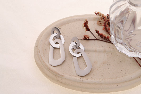 Boucle d'oreilles argentées pendantes trio de formes arrondies reliées