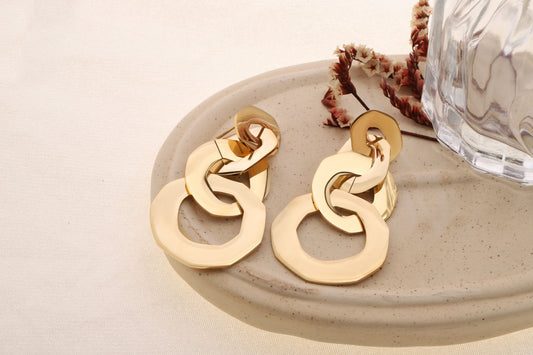 Boucle d'oreilles dorées pendantes quatuor de formes arrondies reliées