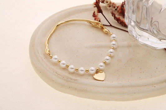 Bracelet doré semi- rigide coté perles blanches et charm cœur fermeture crochet