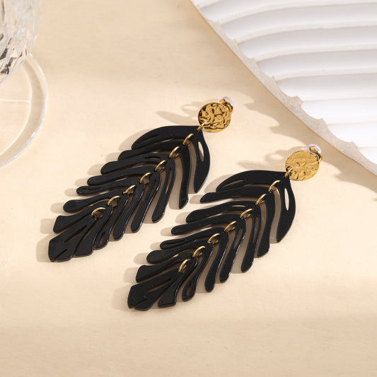 Boucles d'oreilles pendantes dorées motif feuilles articulées noires