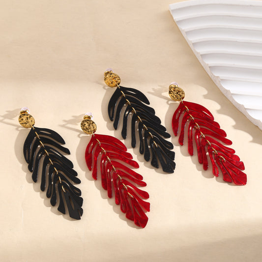 Boucles d'oreilles pendantes dorées motif feuilles articulées noires