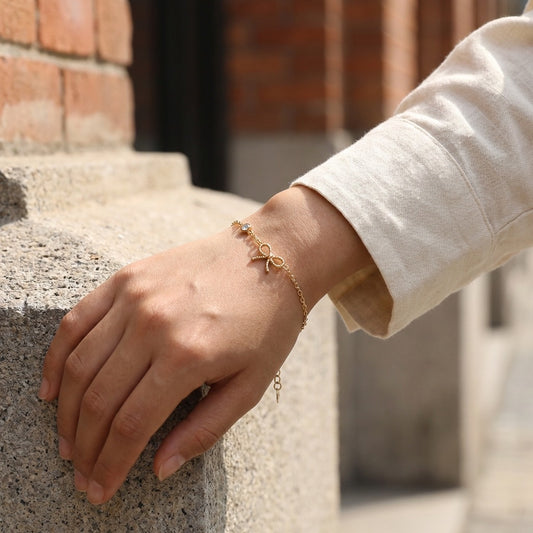 Bracelet fin orné d’un nœud ajouré spiralé et d’un strass rond