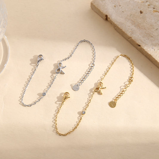 Bracelet fin orné d’un nœud ajouré spiralé et d’un strass rond