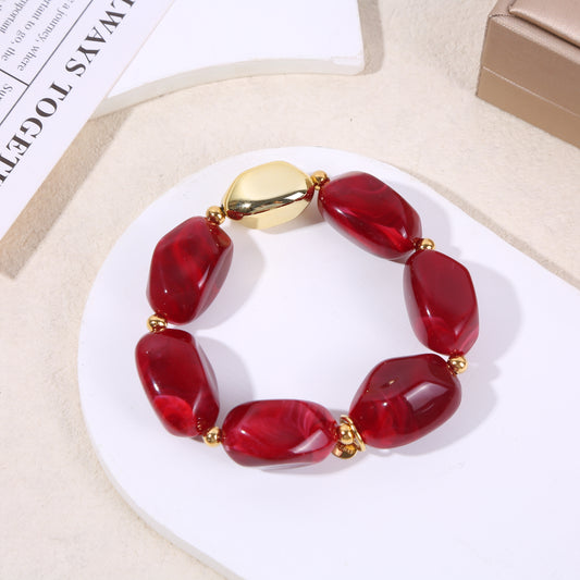 Bracelet élastique doré résine rouge bordeaux marbrée formes arrondies