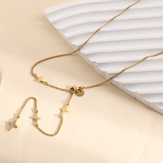 Collier doré chaîne fine sertie d'étoile 4 branches fermoir et une étoile strassée