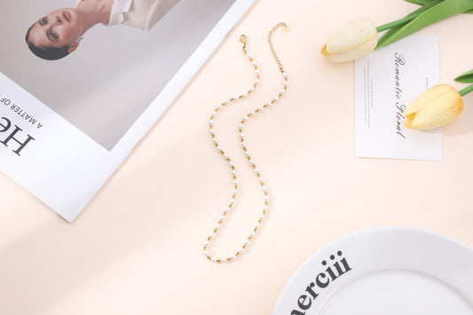 Collier doré orné de perles blanche classique