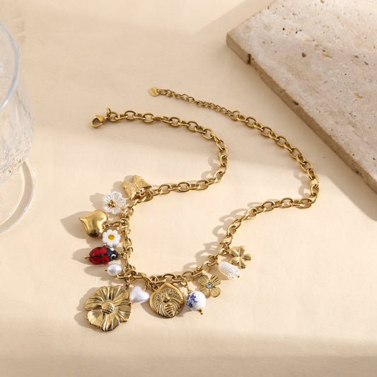 Collier chaîne dorée à pampilles fleuries, breloques cœurs, coccinelle émaillée et médaillon gravé