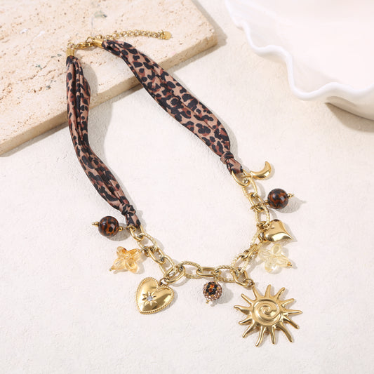 Collier chaîne texturée dorée tissu léopard pendentifs résine et soleil large