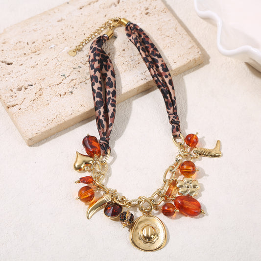 Collier chaîne texturée dorée tissu léopard pendentifs cowboy et résine ambrée
