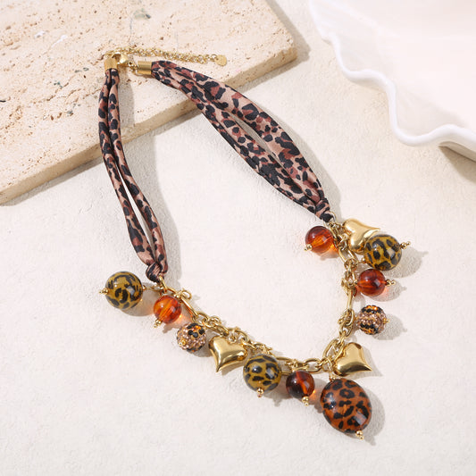 Collier chaîne dorée tissu léopard pendentifs et résine léopard