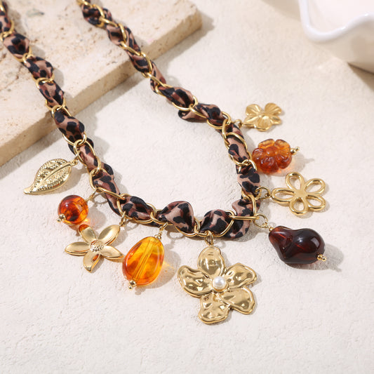 Collier chaîne dorée ornée tissu léopard résine ambrée et grande fleur