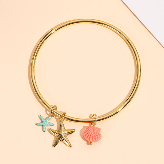 Bracelet doré jonc pendant étoiles de mer et coquillage