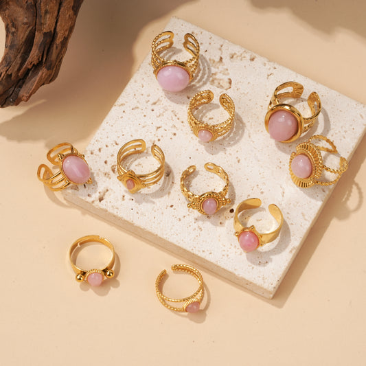 Lot de 10 bagues dorées à cabochon rose sur présentoir