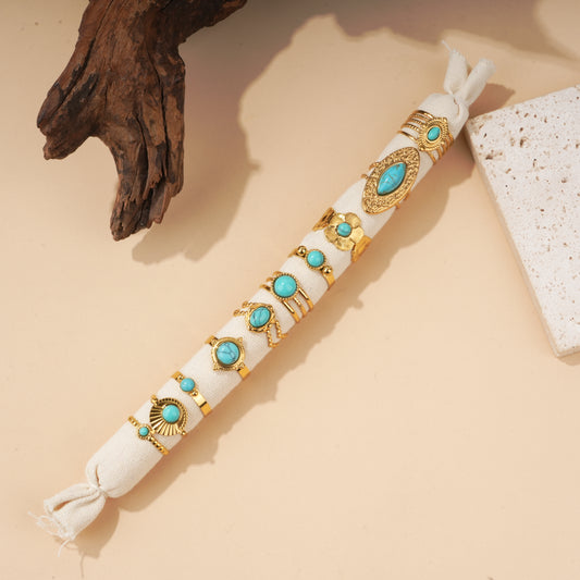 Lot de 10 bagues dorées à pierre turquoise sur présentoir