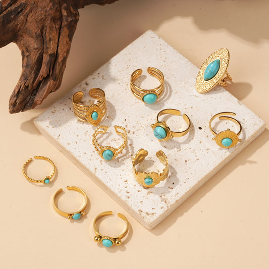 Lot de 10 bagues dorées à pierre turquoise sur présentoir