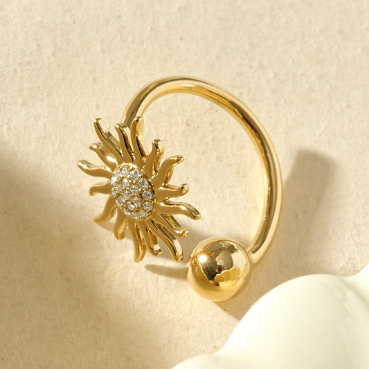 Bague dorée ouverte à l’avant avec soleil strassé et bille
