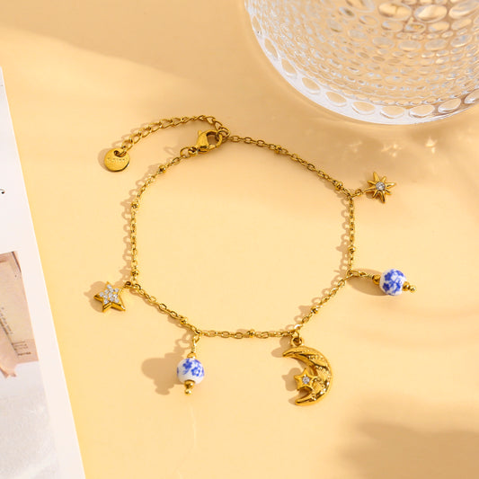 Bracelet doré à breloques constellations et boules de porcelaines bleues