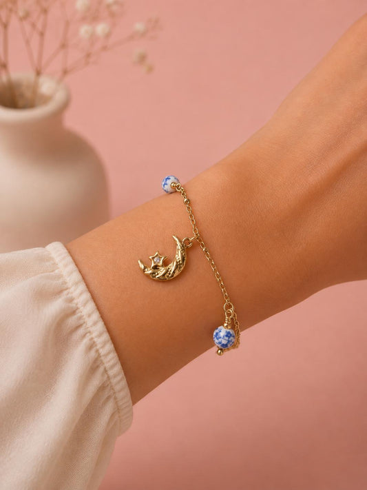 Bracelet doré à breloques constellations et boules de porcelaines bleues