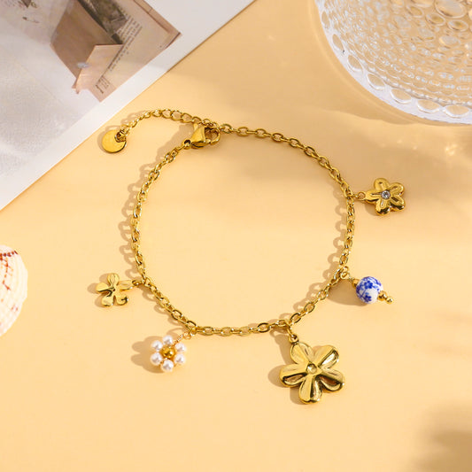 Bracelet doré à breloques fleurs et perle