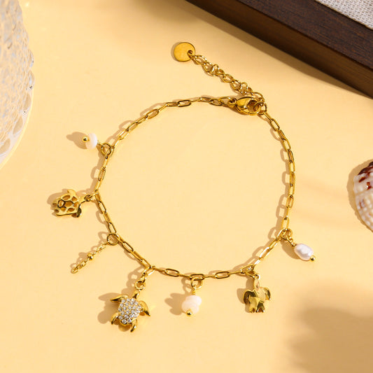 Bracelet doré à charms tortue strassée et perles blanches