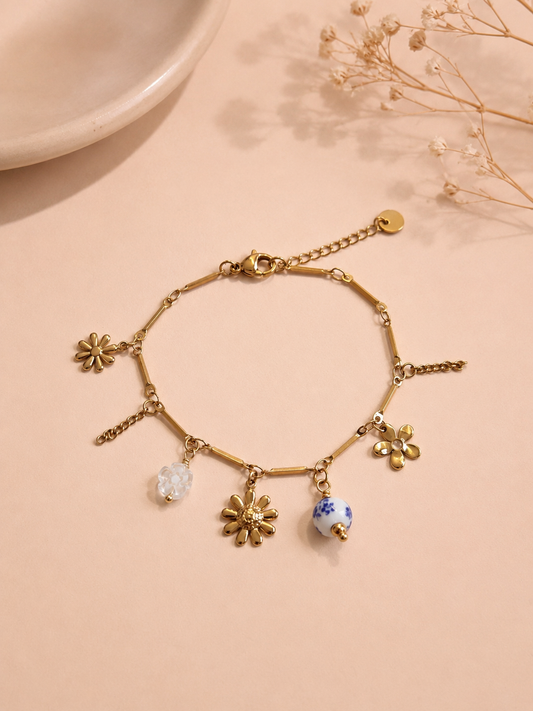 Bracelet doré à charms floraux et porcelaine bleue