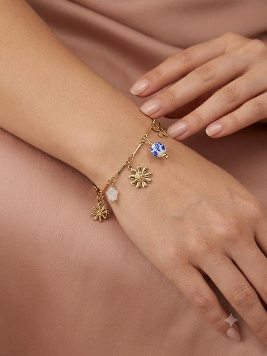 Bracelet doré à charms floraux et porcelaine bleue