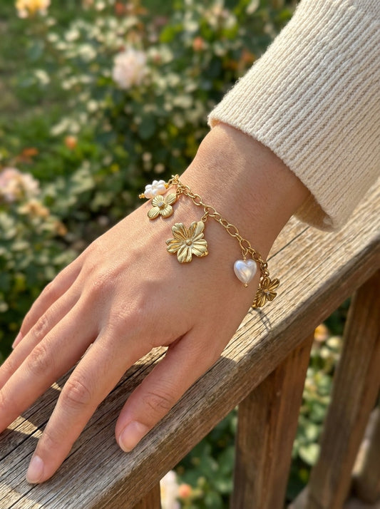 Bracelet doré à charms floraux et cœur en perle
