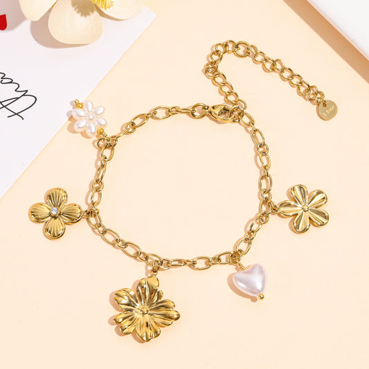 Bracelet doré à charms floraux et cœur en perle