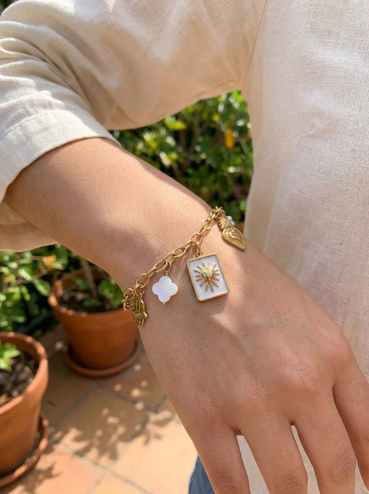 Bracelet doré à charms ex-voto soleil, cœur et trèfle nacré