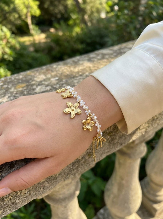 Bracelet chaîne doré orné de perles et pendentifs floraux
